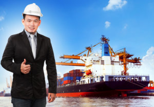 man showing thumbs up with cargo ship at the back
